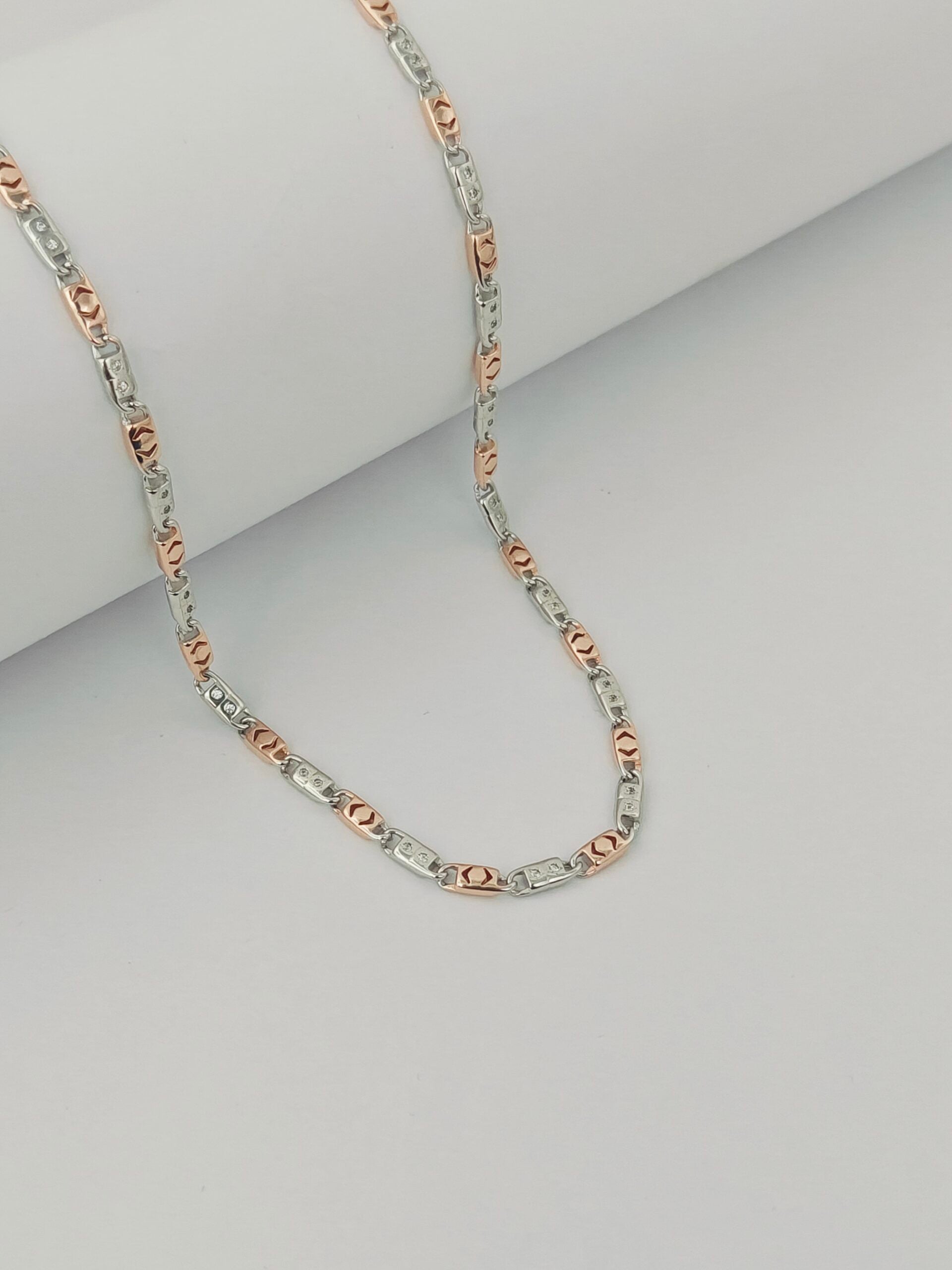 Two-tone silver and rose gold chain necklace on a light gray background
